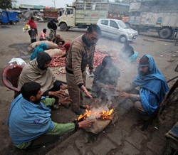 Laborers keep themselves warm near a bonfire on a cold and foggy morning in Jammu, India. More than 100 people have died of exposure as northern India deals with historically cold temperatures. (AP Photo