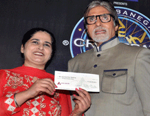 Amitabh Bachchan along withSunmeet Kaur Sawhney, holding a cheque of Rs 5 crores , after winning Kaun Banega Crorepati season 7 in Mumbai on Saturday. PTI Photo