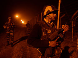 An Indian Border Security Force (BSF) soldiers patrol along the border fence at an outpost along the India-Pakistan border in Suchit-Garh, 36 kms southwest of Jammu on January 11, 2013. Pakistan summoned the Indian ambassador to protest against 'unacceptable and unprovoked' attacks by the Indian army that killed two Pakistani soldiers in five days in Kashmir. AFP