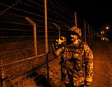 An Indian Border Security Force (BSF) soldier patrols near the fenced border with Pakistan in Suchetgarh, southwest of Jammu January 12, 2013. At least four soldiers, two each from India and Pakistan, have been killed in clashes since last Sunday in disputed Kashmir, where the nuclear-armed enemies are separated by a Line of Control (LoC) set up in 1948. REUTERS/