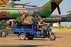 A French soldier drives a motorbike carrying his comrades at the Mali air force base near Bamako on Saturday.  Reuters