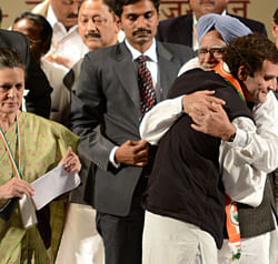 Rahul Gandhi (R) hugs Indian Prime Minister Manmohan Singh before delivering his first speech as Congress party Vice-President while Gandhi's mother and Congress Party President Sonia Gandhi (L) looks on during the Congress party leadership conclave in Jaipur on January 20, 2013. Rahul Gandhi, newly named to the number two post in India's ruling Congress party, delivered a powerful call for change to meet the aspirations of the nation's 'young and impatient' population. AFP PHOTO/STR