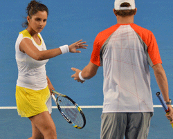 Sania Mirza of India (L) touches hands with playing partner Bob Bryan of the US during their mixed doubles match against Samantha Stosur and Luke Saville of Australia on the fifth day of the Australian Open tennis tournament in Melbourne on January 18, 2013. AFP PHOTO