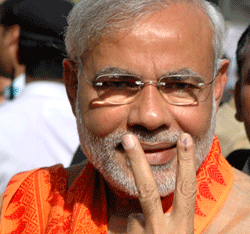Gujarat state Chief Minister and Bharatiya Janata Party leader Narendra Modi displays the victory symbol as he returns after casting his vote in Ahmadabad, India, Thursday, April 30, 2009. The third phase of the five-phased Indian general elections is being held Thursday. AP photo