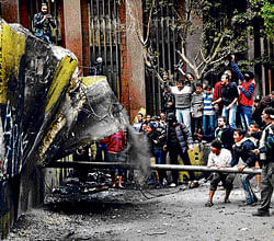 Egyptian protesters try to tear down a cement wall built to prevent them from reaching parliament and the Cabinet building near Tahrir Square in Cairo on Thursday. ap