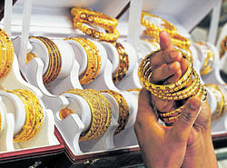 ALL THAT&#8200;GLITTERS: A customer tries gold bangles inside a jewellery showroom at Noida. REUTERS