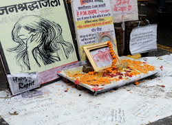 An activist walks past a memorial for the murdered gang rape victim at Jantar Mantar in New Delhi on February 5, 2013. The companion of an Indian medical student who died after being gang-raped on a bus in New Delhi was to begin giving evidence on Tuesday in the trial of five adults accused of her murder, his father said. AFP PHOTO