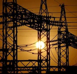 The sun sets behind electric pylons in Allahabad February 22, 2006. REUTERS