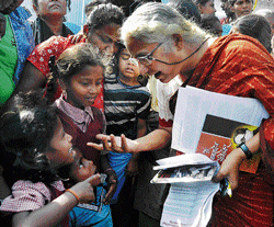 helping hand: Social activitist Medha Patkar has a word with a group of children at  Ejipura EWS quarters on Thursday. DH Photo