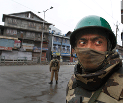 A paramilitary soldier stands guard on a road during a curfew in Srinagar, India, Friday, Jan. 15, 2013. Authorities have re-introduced a strict curfew across most of Indian-controlled Kashmir ahead of Friday prayers, as residents in the region simmer with anger over the secret execution of a Kashmiri man in the capital. (AP Photo/