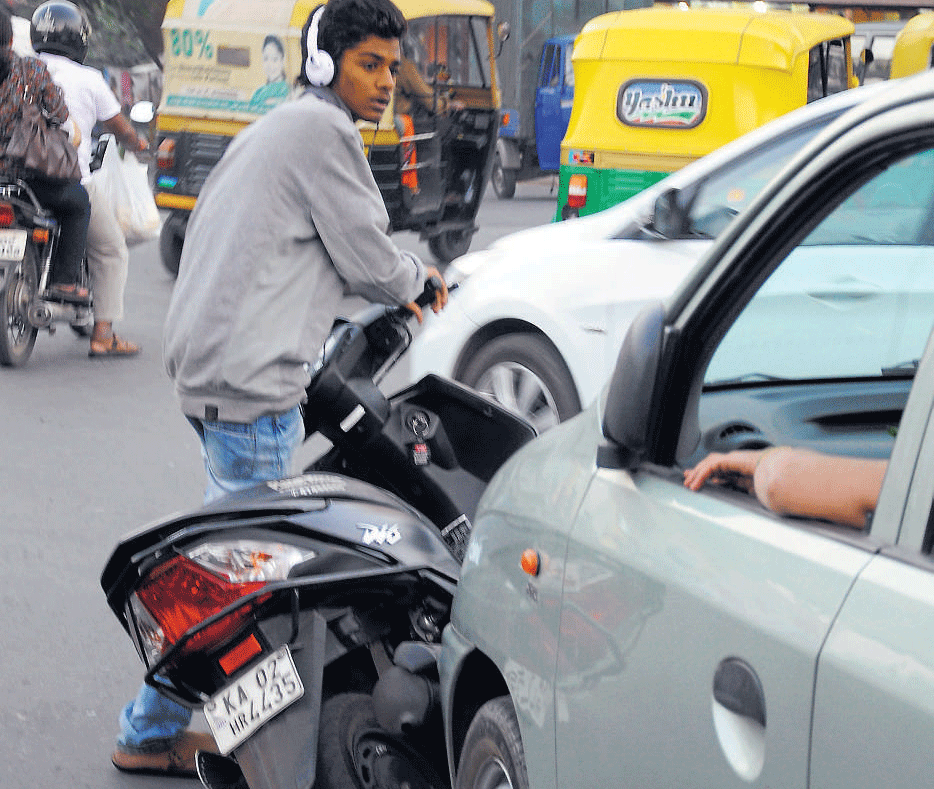 Dangerous: Two wheelers toppling over is a common sight. DH Photo by Dinesh S K