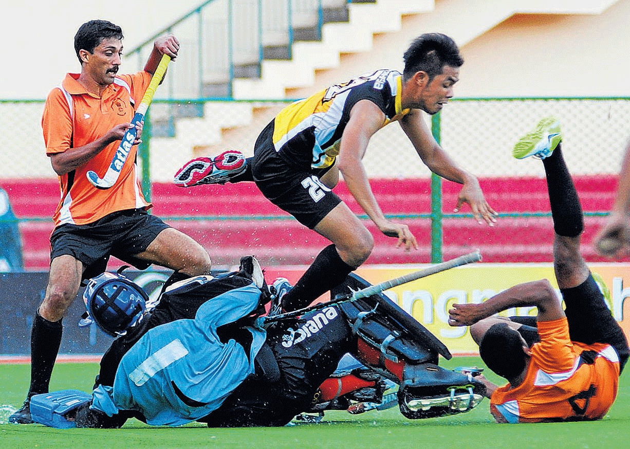 ROCK SOLID: Central Excise goalkeeper Aravind tackles Syamim Mohd Yusof  of Malaysian junior team during their Super Division league match on Sunday. Dh PHOTO