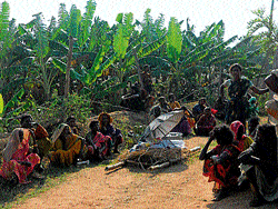 Alleging that the burial ground for scheduled tribes has been encroached upon in Daasanapura haadi of Hanagodu hobli in Hunsur taluk, tribals stage a protest demonstration in front of a body on Tuesday. DH&#8200;PHOTO