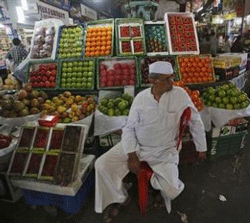 A fruit seller waits for customers at his stall at a wholesale market in Mumbai February 14, 2013. REUTERS