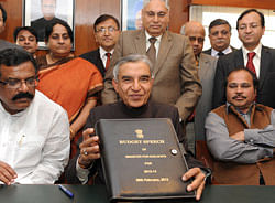 Railway Minister Pawan Kumar Bansal (C) poses with a folder containing this year's Railway Budget, to be tabled tomorrow in Parliament, at his office in New Delhi on February 25, 2013. The railway, the country's largest employer with some 1.4 million people on its payroll, runs 11,000 passenger and freight trains and carries 19 million people daily. AFP PHOTO