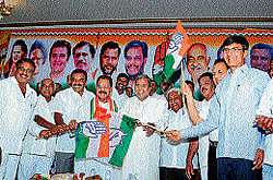 Opposition leader Siddaramaiah welcomes C Basavegowda and others to Congress in a public meeting held in Mysore on Monday. dh photo