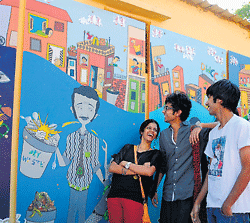 art from waste: Artists with their murals made out of dry waste at the Dry Waste Collection Centre at Freedom Park on Tuesday. dh Photo