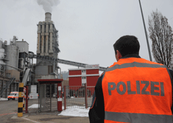 A police officer stands on February 27, 2013 in a front of the Kronoswiss wood panel plant in Menznau, near Lucerne, where two people were killed and seven others wounded when a gunman opened fire earlier in the day. The gunman was among the dead, according to a police spokesman, without saying whether he had committed suicide or been shot by police. AFP PHOTO