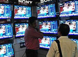 A man walks past television screens showing an advertisement for a program on India's annual budget at an electronics shop in Mumbai in this February 22, 2013 file photo. India's economy will grow 6.1-6.7 percent in the financial year that starts in April, the government forecast in a report on Wednesday, a day before Finance Minister P. Chidambaram unveils a budget that is expected to keep a lid on spending. Picture taken February 22, 2013. REUTERS