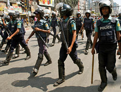 Riot policemen escort Bangladeshis protesting against a strike called by Jamaat-e-Islami activists to denounce the trial by a special tribunal involving several of their leaders in Dhaka, Bangladesh, Thursday, Feb. 28, 2013. A special war crimes tribunal in Bangladesh on Thursday sentenced Delwar Hossain Sayedee, the leader of the Islamic political party to death for crimes stemming from the nation's 1971 fight for independence, a politically charged decision that sparked violent protests. (AP Photo/Pavel Rahman)