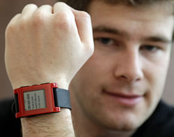 Eric Migicovsky, CEO of Pebble, displays his company's smart watch in Palo Alto, California.  This new watch not only tells time, but also connects to smart phones within 10 meters. (AP Photo