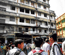 A day after a major fire, school students look at the burnt building in Sealdah market in Kolkata on Thursday. PTI