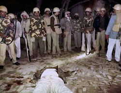 Dead body of Deputy Superintendent of Police Zia ul Haq is seen lying on the ground as policeman stand guard in Pratapgarh on Saturday night. The DSP had received gunshots during an exchage of fire between the police and the villagers following murder of the village chief, and he later succumbed to his injuries. PTI Photo