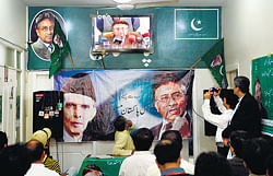 Waiting for leader: Activists of All Pakistan Muslim League (APML) watch the press  conference of their leader, former Pakistan President Pervez Musharraf, on television at the party office in Karachi on Friday.  AFP