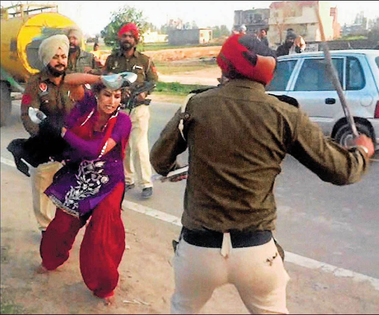 Abusing power: Police personnel beating a woman after after she, along with her father, tried to lodge a complaint against molestation by some truck drivers in Taran Taran on Monday.