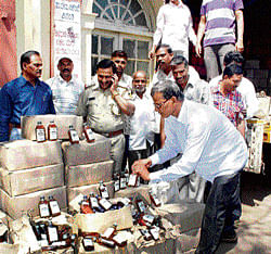 Taking account: Liquor bottles that were seized by the Excise Enforcement and Lottery Prohibition wing of the police near Belgaum on Tuesday. dh photo