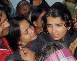 Wife of slain police officer Zia-ul-Haq mourns his death at their residence in Deoria. PTI Photo