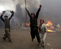 Pakistani men, part of an angry mob, react after burning belongings of Christian families, in Lahore, Pakistan, Saturday, March 9, 2013. A mob of hundreds of people in the eastern Pakistani city of Lahore attacked a Christian neighborhood Saturday and set fire to homes after hearing accusations that a Christian man had committed blasphemy against Islam's prophet, said a police officer. AP Photo