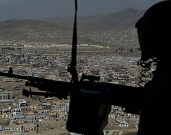 A US helicopter door gunner looks on during a flight carrying women on a ride with the Afghan Air Force in Kabul. AFP Photo