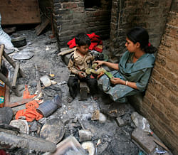 A Pakistani Christian sits with her son in her damaged house after it was burnt by mob a day earlier in Badami Bagh, Lahore March 10, 2013. Hundreds of Pakistani Christians took to the streets across the country on Sunday, demanding better protection after a Christian neighbourhood was torched in the city of Lahore a day earlier in connection with the country's controversial anti-blasphemy law. REUTERS
