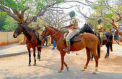 Mounted police on guard during the counting of votes in front of Maharanis College in Mysore on Monday. dh photo