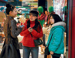 seeking a spouse: Yang Jing, centre, and an assistant, right, talk to a woman about signing up to Diamond Love and Marriage, a  matchmaking service, at the open-air mall Sanlitun Village in Beijing. NYT