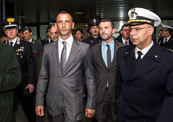This Feb. 23, 2013 photo made available Wednesday, March 13, 2013 shows Italian marines Massimiliano Latorre, center left, followed by Salvatore Girone, second from right, upon their arrival from India at Rome's Leonardo da Vinci airport, in Fiumicino. India's prime minister demanded Wednesday that Italy return two marines accused of killing a pair of fishermen last year or face unspecified consequences, deepening a diplomatic dispute between the two countries. The Indian government allowed the marines to return home in February to vote in national elections and to celebrate Easter with a promise from the Italian ambassador that they would return to stand trial. Italy announced Monday it would not send them back. AP Photo