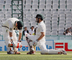 Australian player D Warner and E D Cowan during the second day of the 3rd Test match against India at PCA Stadium in Mohali on Friday. Australia won the toss and elected to bat. PTI Photo