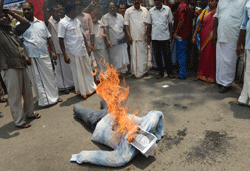Demonstrating Indian fishermen burn an effigy of Indian Prime Minister Manmohan Singh as they shout slogans against the ruling UPA government in Trivandrum, capital of the southern Indian state of Kerala, on March 13, 2013, against the government's handling of the two Italian Marines on trial for murder. India's Prime Minister Manmohan Singh warned Italy on Wednesday that there would be 'consequences' unless it returned two of its marines who skipped bail while on trial in New Delhi for murder. AFP PHOTO