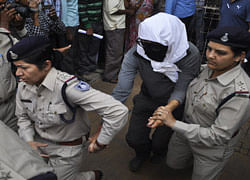 A Swiss woman with her face covered is taken to a hospital by police for her medical examination at Gwalior in the central Indian state of Madhya Pradesh March 16, 2013. Four men raped a 39-year-old Swiss woman camping with her husband in an Indian forest, police said on Saturday, turning the spotlight anew on the security of women in the world's largest democracy. REUTERS