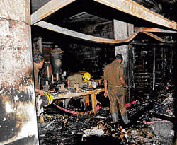 Beyond salvage Firemen examine the damage after a fire destroyed a shoe factory near Mysore Road on Sunday.  DH photo