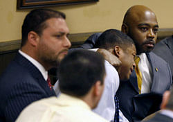 Defense attorney Walter Madison, right, holds his client, 16-year-old Ma'Lik Richmond, second from right, while defense attorney Adam Nemann, left, sits with his client Trent Mays, foreground, 17, as Judge Thomas Lipps pronounces them both delinquent on rape and other charges after their trial in juvenile court in Steubenville, Ohio, Sunday, March 17, 2013. Mays and Richmond were accused of raping a 16-year-old West Virginia girl in August 2012. (AP Photo)