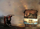 Firemen douse a burning bus set on fire allegedly by activists of BNP in Dhaka on Sunday.  AP Photo