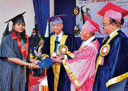 Sri D Devaraj Urs Academy of Higher Education and Research president R L Jalappa conferred a gold medal on Dr E Sneha at the convocation ceremony in Kolar on Saturday. DH Photo