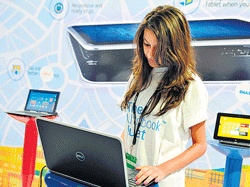 A participant checks out a laptop at an exhibition stall during the TechEd 2013 technology event organised by Microsoft in Bangalore on Monday. AFP