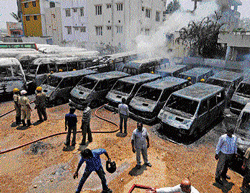 Destroyed: Vehicles of a private firm gutted at Murugesh Palya on Monday. DH Photo