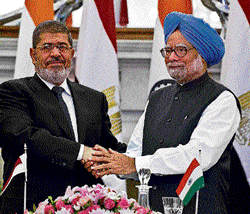 Prime Minister Manmohan Singh shakes hands with  Egyptian President Mohamed Morsy after a meeting in New Delhi on Tuesday.  AFP