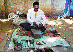 Rathnaiah, a cobbler in Gauribidanur, who was elected to the Town Municipal Council from Santhe Maidan, ward 6, recently, seen at work. dh photo