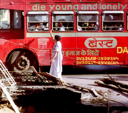 (FILES) Int his photograph taken on March 16, 1993, an Indian pedestrian is passed by a double-decker bus as she walks past bomb blast debris in Mumbai. India's top court upheld the death penalty on March 21, 2013, for a mastermind of the country's deadliest attacks in a hearing which also saw Bollywood actor Sanjay Dutt sentenced to five years in jail. Yakub Memon, brother of the alleged main plotter and fugitive Tiger Memon, was the only one among 11 convicts to see his death sentence upheld for his leading role in the blasts which also wounded more than 800 people. AFP PHOTO