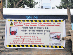 Creating Awareness: Posters by the Railway Protection Force appealing to people not to throw stones at trains.  DH photo by Janardhan B K